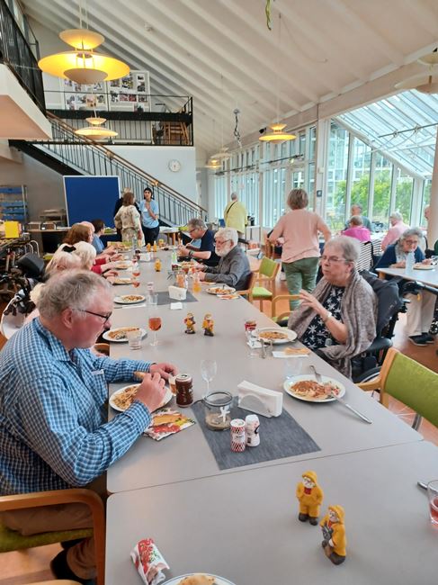 Beboere, pårørende og personale spiser efter fællessang i cafeen Tolleruphøj
