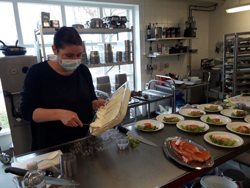 Medarbejder tilbereder portionsanrettet påskefrokost i køkkenet på Tolleruphøj