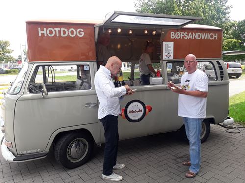 Carsten Rønnest og Bosse fra Shu-bi-duo spiser hotdogs ved pølsevognen udenfor Tolleruphøj