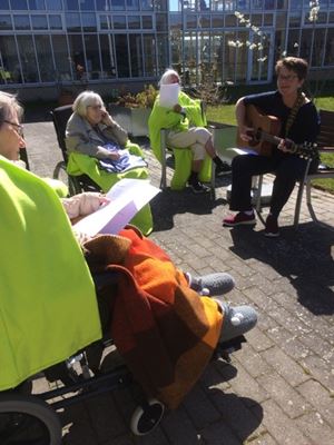 udendørs fællessang i flot solskin med beboere og personale i haven på Tollerruphøj i anledning af dronning Margrethes 80-års fødselsdag.