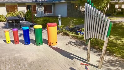 farverige sambatrommer og lydrør i haven på Tolleruphøj