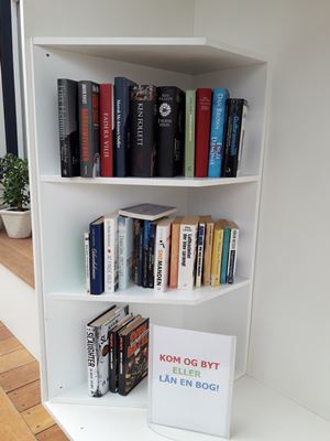 kom og byt en bog: reol med bøger til lån og byt