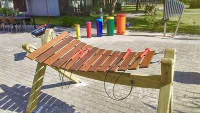 farverige sambatrommer, lydrør og træxylofon i haven på Tolleruphøj