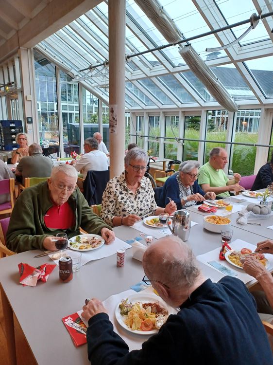 Beboere, pårørende og personale sidder i cafeen på Tolleruphøj og spiser heltstegt pattegris