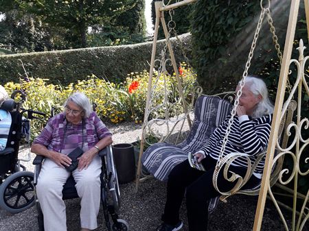 beboere i kørestol og hængesofa nyder soler i Birkegårdens have